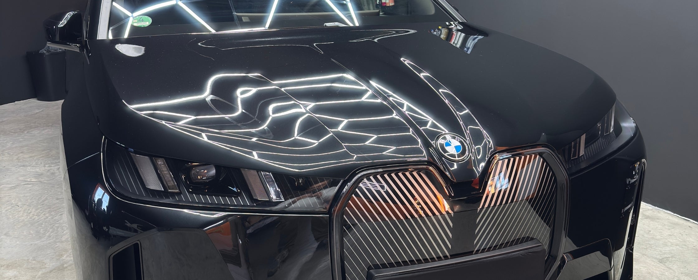 Elektrischer BMW mit schwarzem Lack nach der professionellen Keramikversiegelung von First Detailing aus Würzburg.