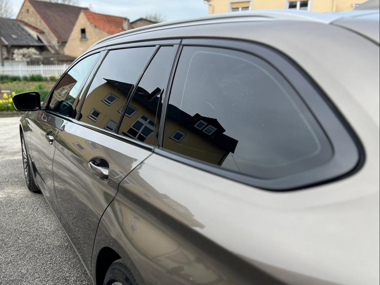 Ein beiger Kombi mit schwarzen Scheiben